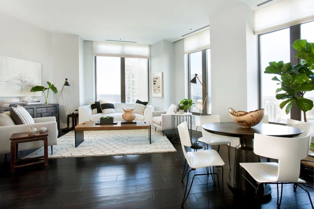 Studio living area with a sofa, plants and tall windows