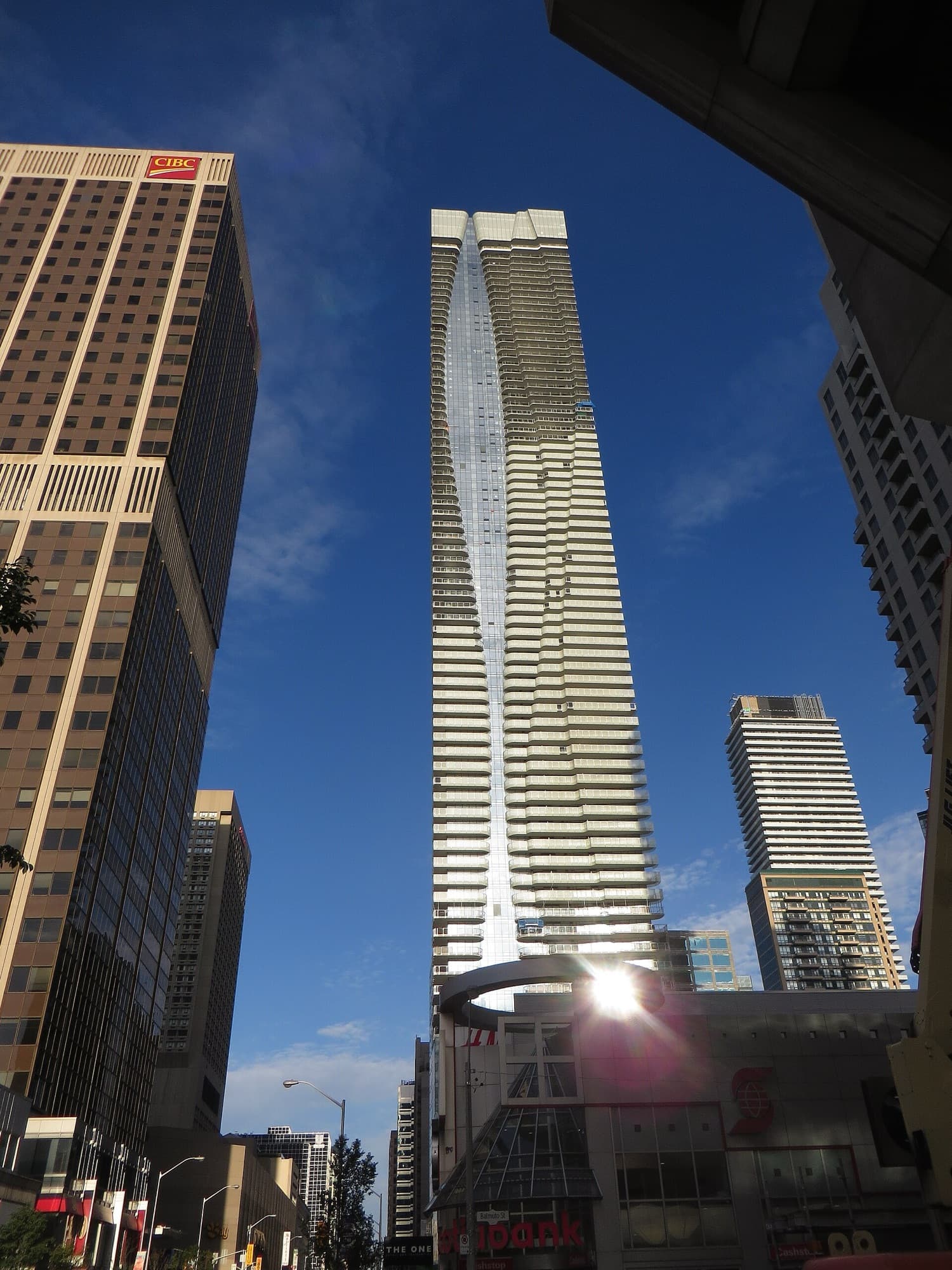 Towers at Yonge and Bloor in Toronto against a clear sky, seen from street level