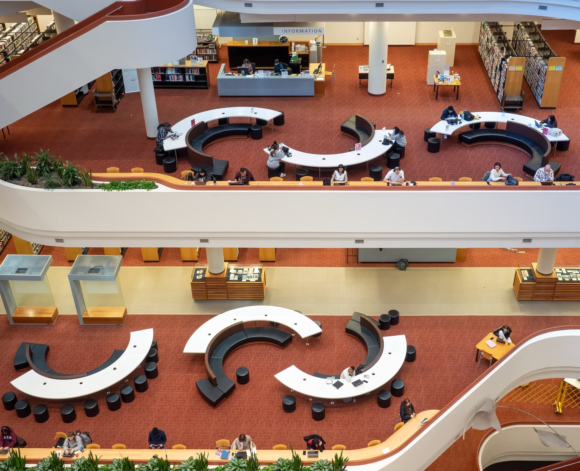 The atrium of the Toronto Reference Library seen from an upper floor, with curved study desks below