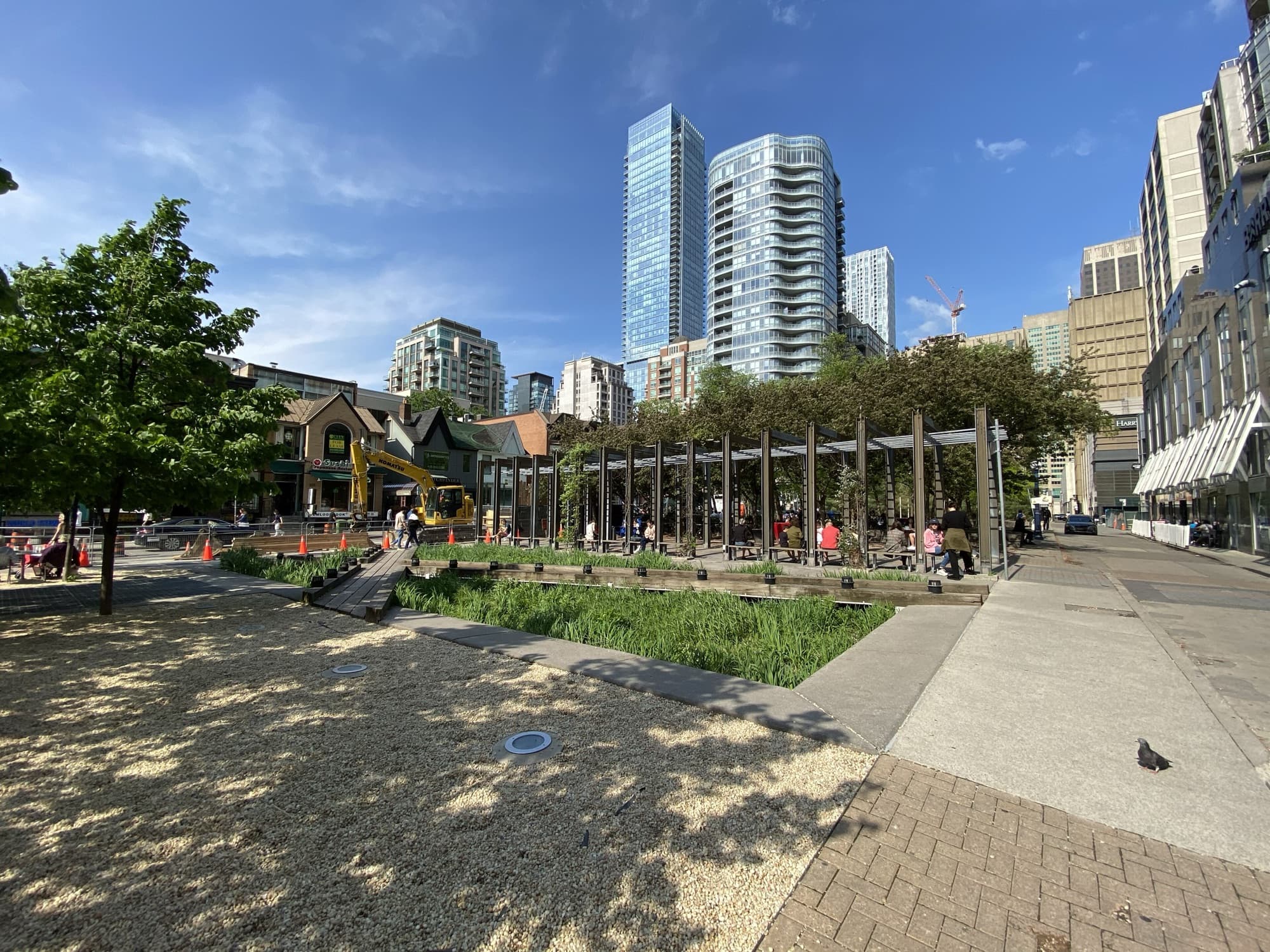Village of Yorkville Park with gravel paths, a pergola and towers behind